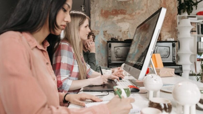 Trois personnes travaillant sur un ordinateur dans un bureau.