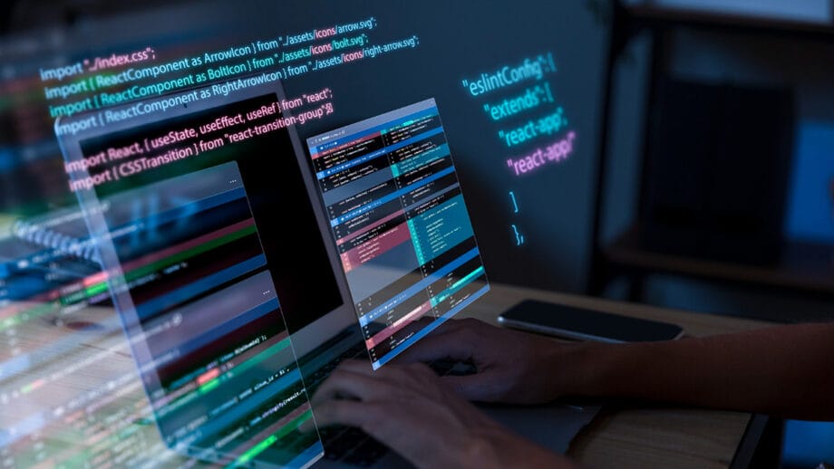 Une personne travaillant sur un ordinateur portable avec du code à l’écran.