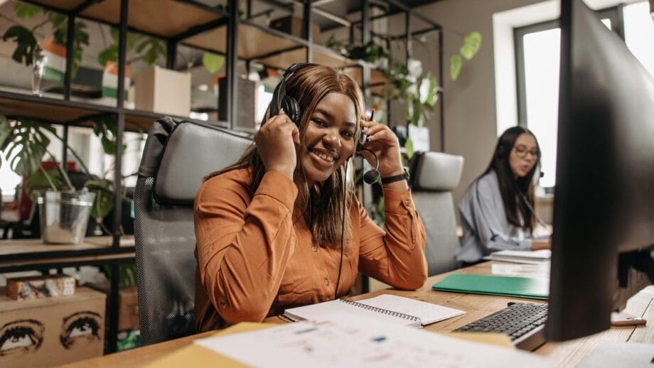 Une femme portant des écouteurs à un bureau dans un bureau.