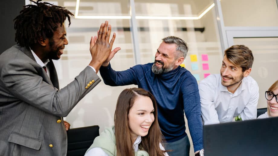 Un groupe de personnes se donnant des high fives dans un bureau.