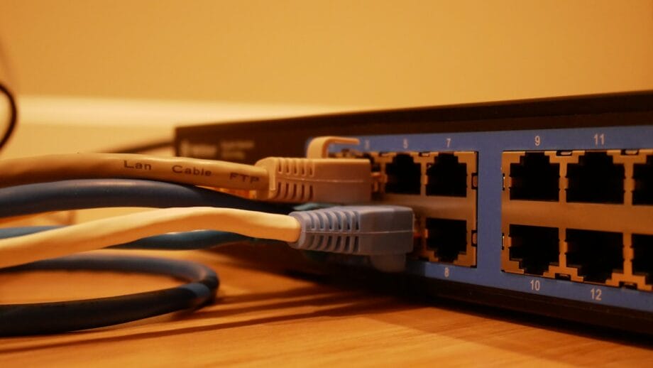 Close-up d'un commutateur de mise en réseau avec plusieurs câbles Ethernet branchés sur ses ports.