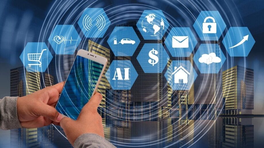 Les mains tenant un smartphone avec plusieurs icônes numériques superposées, notamment le panier, le globe, le courrier électronique et l'IA, dans une toile de fond de la ville.