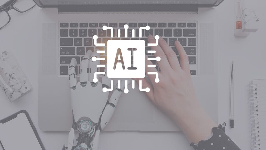 Une main humaine et un type de main robotique sur un clavier d'ordinateur portable, avec une superposition d'icône de microchip AI au centre.