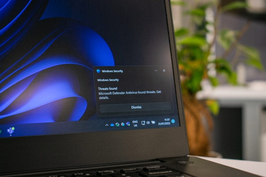 L'écran d'un ordinateur portable affiche une notification de sécurité Windows concernant les menaces détectées sur le système, avec une option permettant d'ignorer l'alerte.