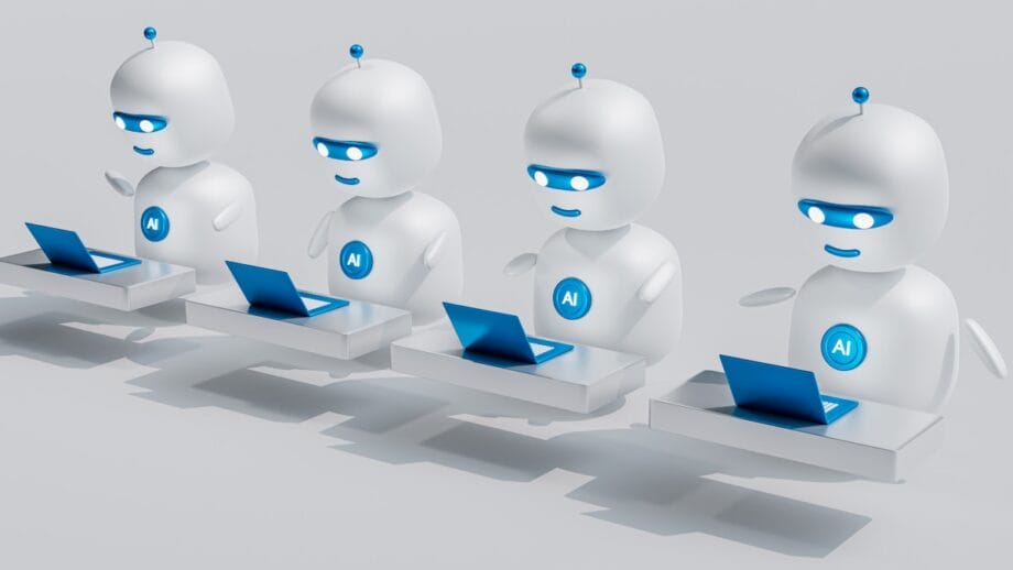 Quatre robots IA blancs avec des accents bleus sont assis à des bureaux, utilisant des ordinateurs portables en rangée, sur un fond clair uni.