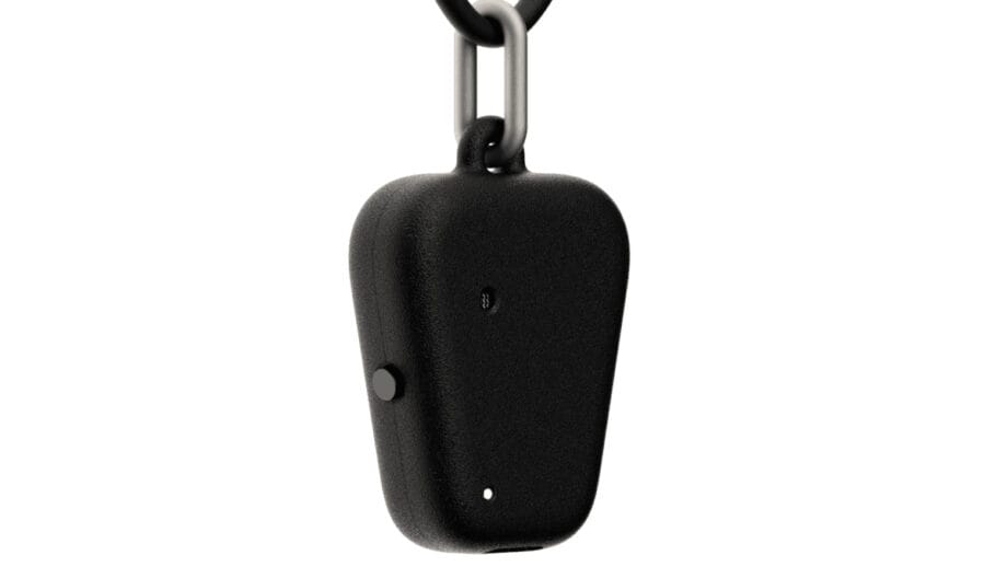 Gros plan d'un petit appareil Fieldy noir avec un bouton et deux petits trous, fixé à un porte-clés en métal.