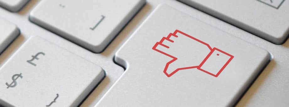 Un gros plan d'un pouce rouge vers le bas sur un clavier.
