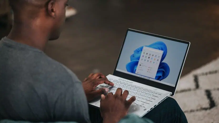 homme en chemise grise à manches longues utilisant un ordinateur Windows 11