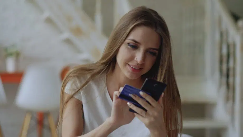 Jeune femme tenant une carte de crédit et un smartphone