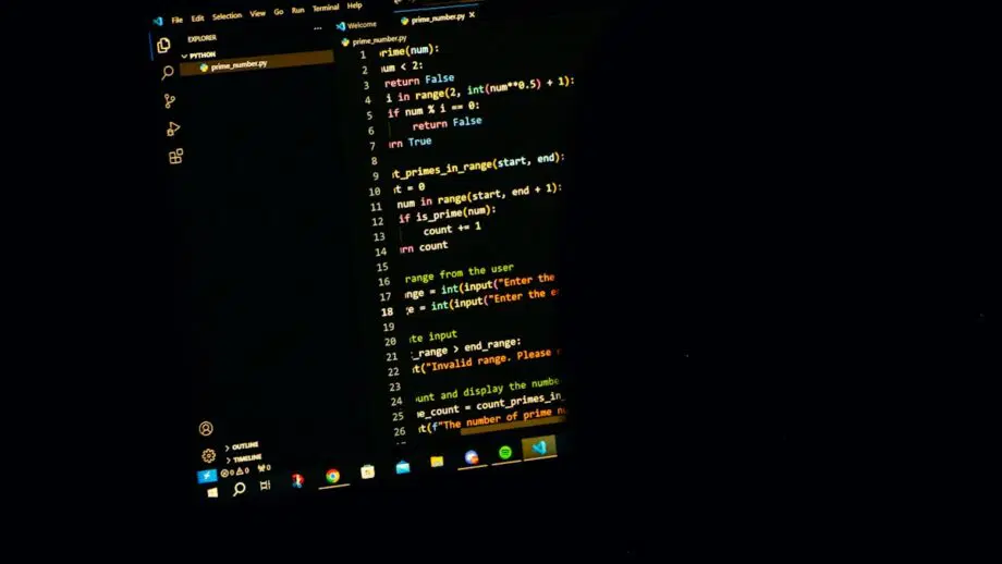 Un écran d'ordinateur affiche du code Python dans un éditeur de texte au thème sombre, montrant une fonction permettant de trouver des nombres premiers dans une plage.