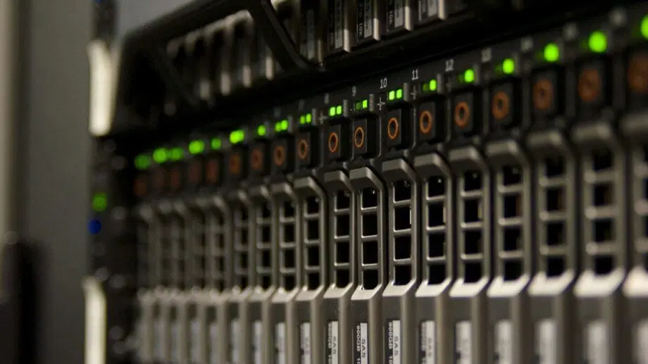 Gros plan d'un rack de serveur avec plusieurs baies de disque dur et voyants lumineux dans un centre de données.